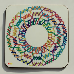 Puede incluir: Un posavasos colorido con un diseño circular que presenta un patrón repetitivo de líneas onduladas superpuestas en tonos de rojo, naranja, amarillo, verde, azul, morado y blanco.