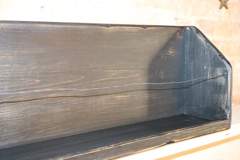 Peut inclure: &Eacute;tag&egrave;re en bois fonc&eacute; avec une finition vieillie. De forme rectangulaire, elle pr&eacute;sente un devant l&eacute;g&egrave;rement inclin&eacute; et un grain de bois visible. La couleur est un charbon profond avec des reflets plus clairs.