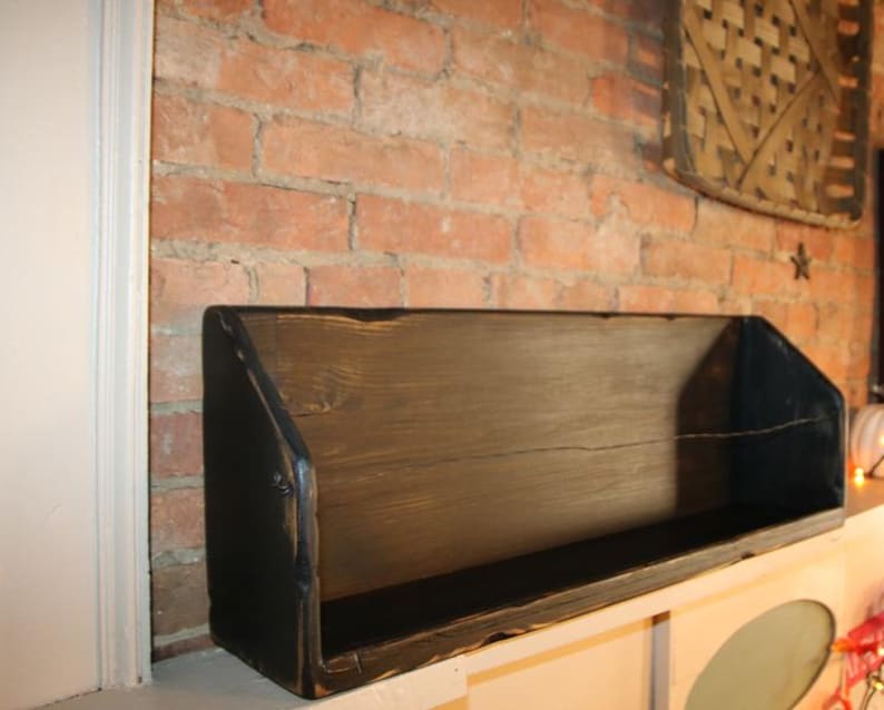 Peut inclure: &Eacute;tag&egrave;re rectangulaire en bois sombre et vieilli, fix&eacute;e contre un mur de briques rouges. Le design est simple et fonctionnel. Ses dimensions sont d'environ 61 cm de long, 20 cm de haut et 15 cm de profondeur, id&eacute;ale pour la d&eacute;coration.