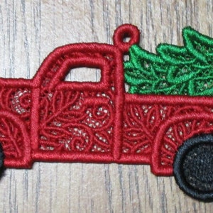 May include: Red truck with a green Christmas tree in the back. The truck and tree are made of red and green lace.