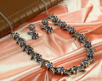 Conjunto de joyas chapadas en plata oxidada: collar y pendientes con piedras.