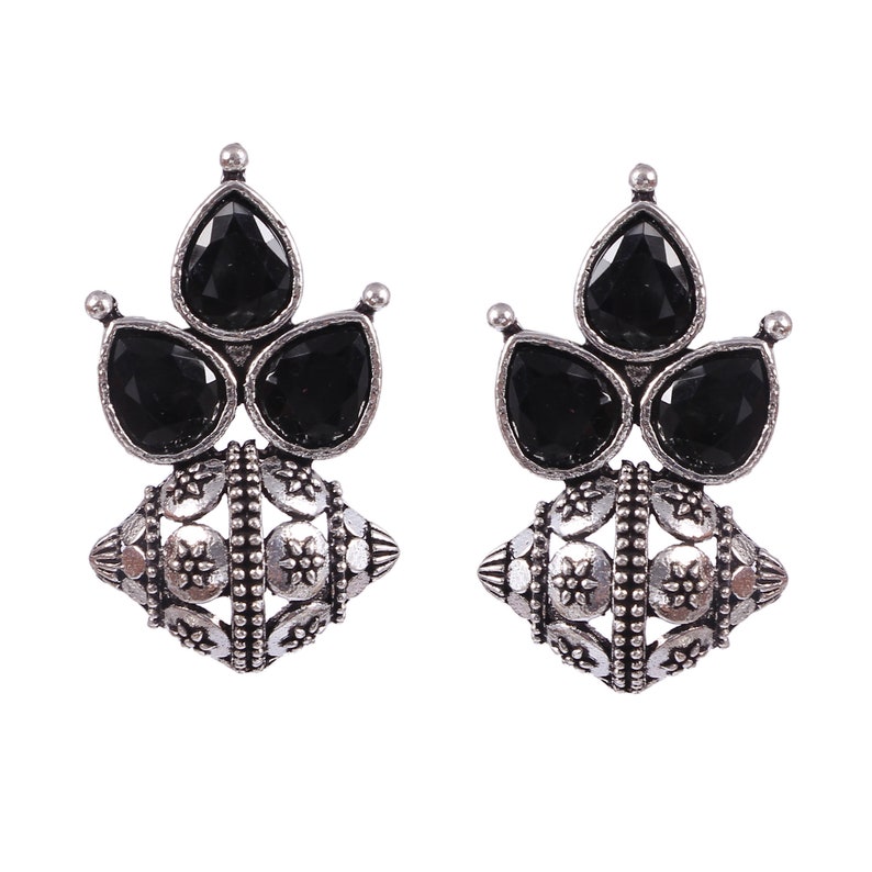 May include: A pair of silver earrings with black gemstone accents. The earrings feature a round, ornate design with three teardrop-shaped gemstones.