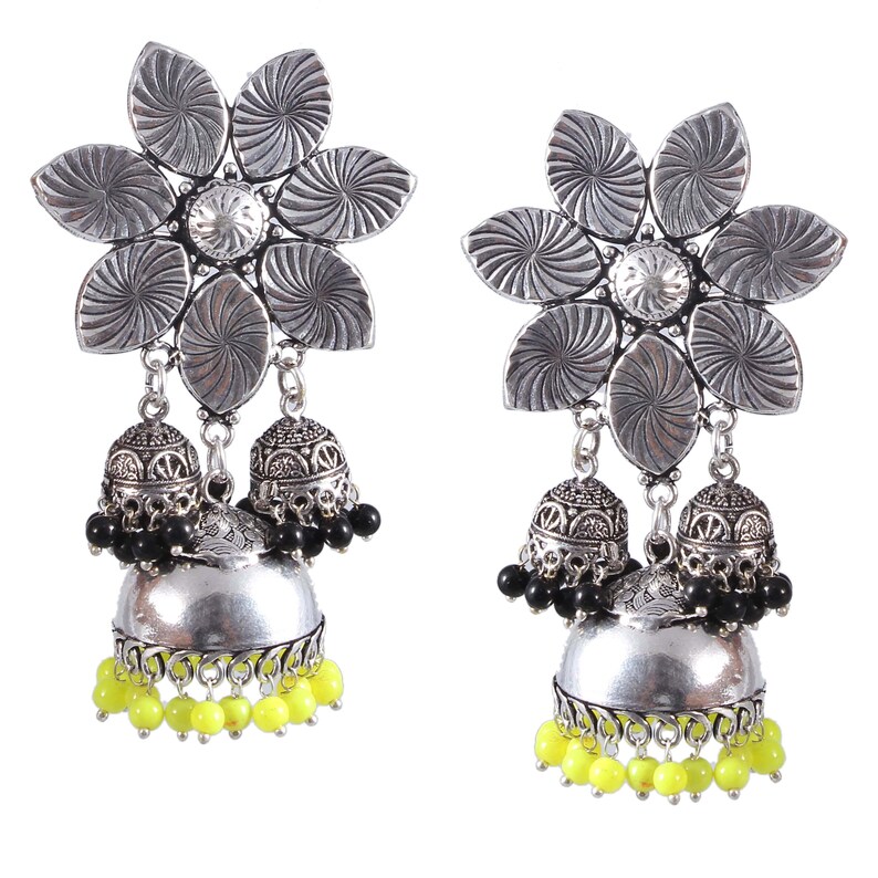 May include: A pair of silver-toned earrings featuring a flower-shaped top with etched details. Each earring has a small, ornate bell-shaped charm with black beads and a strand of yellow beads.