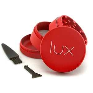 May include: Red metal grinder with a black brush and scraper. The grinder has the word "LUX" printed on the top.