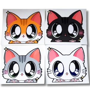 May include: Four square stickers with cartoon cat faces. Each cat has large eyes and a different colour: orange, black, grey, and white. The stickers have a cute, anime-inspired aesthetic.