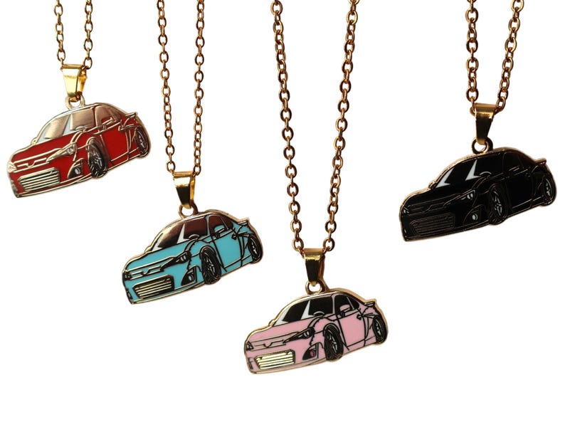 May include: Four gold necklaces with car pendants. The pendants are in red, blue, black, and pink. The cars are all the same style, but in different colors.