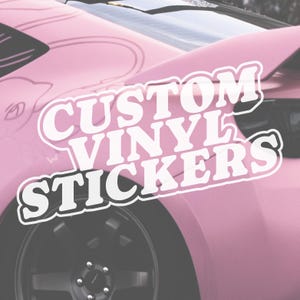 Puede incluir: Un coche rosa con una rueda negra y una superposición de texto blanco que dice "CUSTOM VINYL STICKERS". El coche tiene un alerón y una ventana negra. La imagen está tomada desde un ángulo bajo.