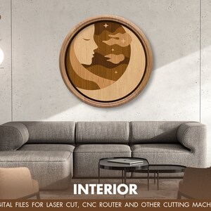 May include: A wooden wall art piece with a carved design of a face and clouds. The design is in shades of brown and beige. The art piece is framed in a circular wooden frame.
