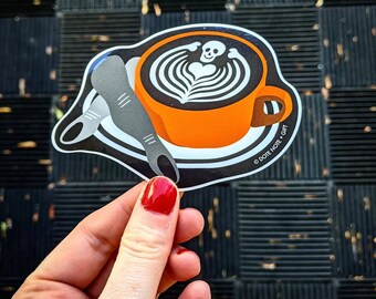 Vinyl Sticker | Skull Latte // Latte art with skull and bones in tea or coffee, with lady fingers. Black and Orange. Halloween. Skeleton
