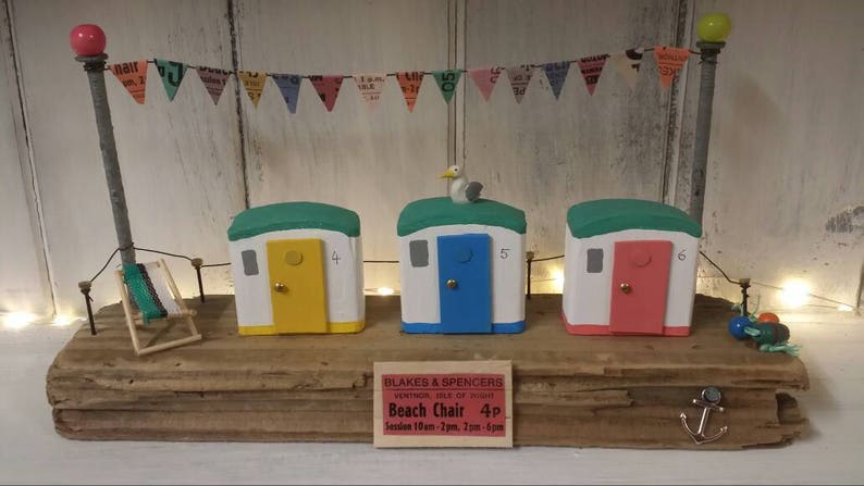 Driftwood art colourful beach huts on the beach