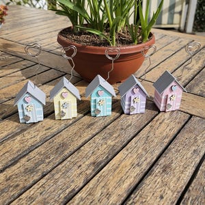 Miniaturowe drewniane domki plażowe w pastelowych kolorach, uchwyty na zdjęcia/karty