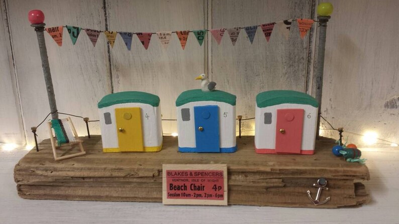 Driftwood art colourful beach huts on the beach