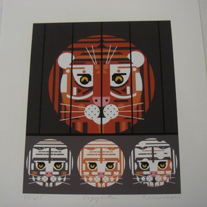 May include: A graphic art print titled Copycats featuring a large orange and white tiger face centered behind black vertical bars. Below, three smaller circular tiger faces are displayed in white, orange, and grey tones on a dark background.
