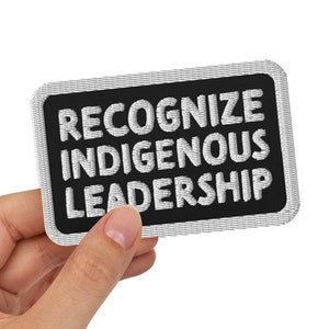 May include: A black patch with white text that reads "Recognize Indigenous Leadership".