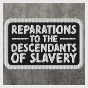 Puede incluir: Parche bordado en blanco y negro con el texto "Reparations to the Descendants of Slavery".