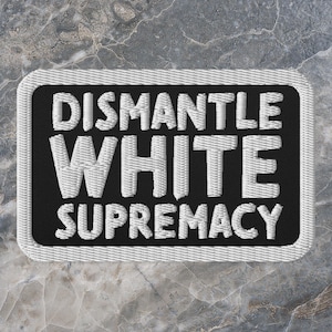 Puede incluir: Parche bordado en blanco y negro con el texto "Dismantle White Supremacy".