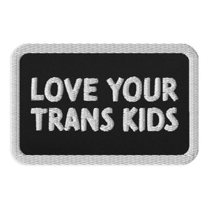 May include: Black and white embroidered patch with the text "LOVE YOUR TRANS KIDS" in white.