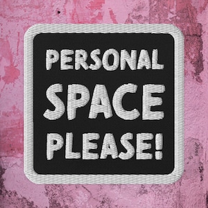 Op de afbeelding: Een zwarte vierkante patch met witte geborduurde tekst die "PERSONAL SPACE PLEASE!" luidt. De patch bevindt zich op een roze textuur achtergrond.
