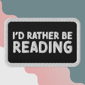 Puede incluir: Parche bordado negro con puntadas blancas que dice "Prefiero estar leyendo".