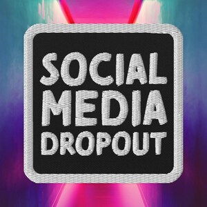 Op de afbeelding: Zwarte en witte geborduurde patch met de tekst "SOCIAL MEDIA DROPOUT" in witte letters.