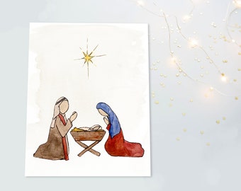 Puede incluir: Una ilustración en acuarela de una escena de natividad con dos figuras arrodilladas a ambos lados de un pesebre de madera que contiene un bebé. Una estrella amarilla brillante con puntas radiantes se sitúa sobre un fondo blanco.