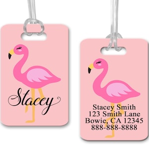 May include: Pink luggage tag with a pink flamingo illustration and the name "Stacey" in black cursive. The tag also includes the text "Stacey Smith, 123 Smith Lane, Bowie, CA 12345, 888-888-8888".