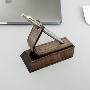 Walnut pen stand on desk displaying pen