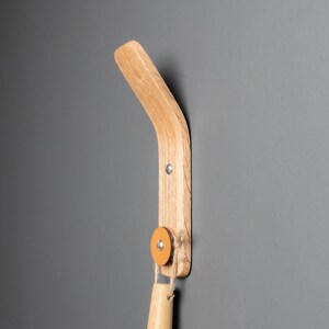 A stylish oak wood wall hook, perfect for organizing aprons, oven mitts, and small kitchen utensils, adding functionality and charm to the kitchen décor