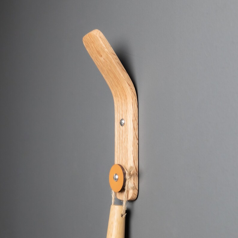 A stylish oak wood wall hook, perfect for organizing aprons, oven mitts, and small kitchen utensils, adding functionality and charm to the kitchen décor