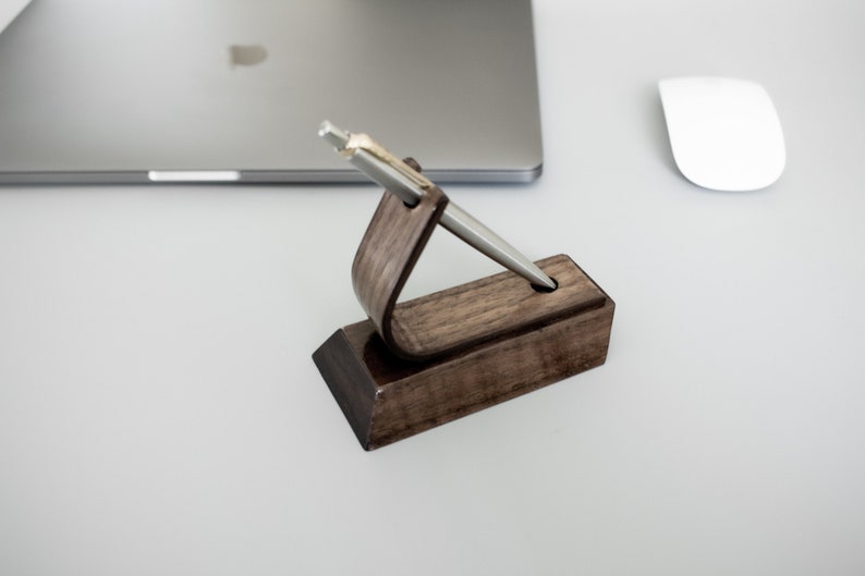 Walnut pen stand on desk displaying pen