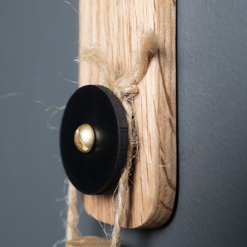 An elegant oak wood wall hook featuring a natural leather accent, providing a gentle and secure hold for towels, bathrobes