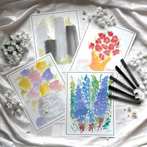 May include: Four watercolour paintings of flowers and abstract shapes. The paintings feature a variety of colours, including red, yellow, blue, and grey. Black pens and white flowers are arranged around the paintings.