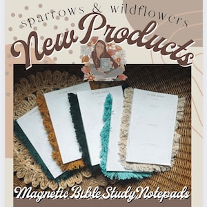 Op de afbeelding: Vijf magnetische notitiebloksets met franjes. Elk notitieblok heeft een witte omslag met de tekst "In the Word" in het zwart gedrukt. De notitieblokken zijn gerangschikt op een geweven strooien mat.