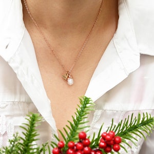 May include: A delicate rose gold necklace with a small heart charm and a white crystal pendant.
