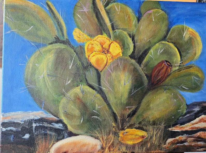 Puede incluir: Una pintura al &oacute;leo sobre lienzo que representa un nopal con paletas verdes, espinas blancas afiladas y una flor amarilla vibrante en plena floraci&oacute;n. Un solo capullo de fruto de color marr&oacute;n rojizo oscuro se ve a la derecha.