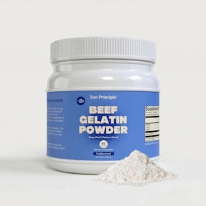 May include: A white plastic jar of "Zen Principle" beef gelatin powder with a blue label. The label reads "BEEF GELATIN POWDER" and "Grass-Fed & Pasture-Raised". A small pile of white powder sits in front of the jar. The jar contains 45 servings.