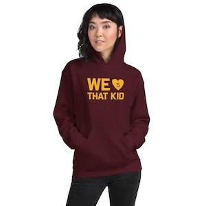 May include: Burgundy hoodie with a gold heart and the text "WE ♥ 5 THAT KID" printed on the front.
