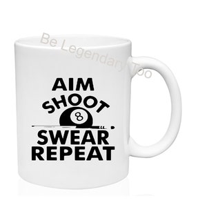 May include: White ceramic mug with a black design that says "AIM SHOOT SWEAR REPEAT" with a black and white 8-ball graphic.
