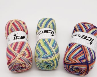 May include: Three colorful yarn skeins with the brand name "ice" visible on the label. The yarn is a mix of colors including pink, yellow, blue, and orange. The skeins are tightly wound and ready for crafting.