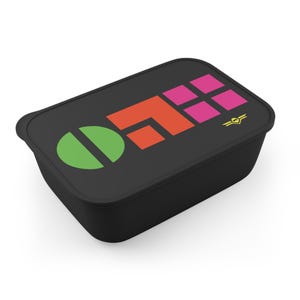 May include: A rectangular black food storage container with a lid featuring a graphic design. The design includes a green circle, an orange geometric shape, four pink squares, and a small yellow winged emblem on the right side of the lid.