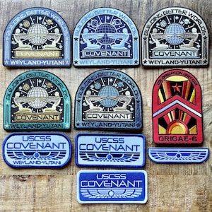 Könnte beinhalten: Eine Sammlung bestickter Aufnäher mit dem Weyland-Yutani-Logo, dem Text Building Better Worlds, Covenant, USCSS Covenant und Colonisation Unit 001 Origae-6. Die Aufnäher zeigen verschiedene Farbkombinationen, darunter Blau, Gold und Rot.