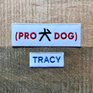 May include: Two white embroidered patches. The top patch has red text that says "(PRO 大 DOG)". The bottom patch has blue text that says "TRACY".