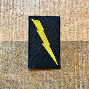 May include: Black fabric patch with a yellow lightning bolt design.