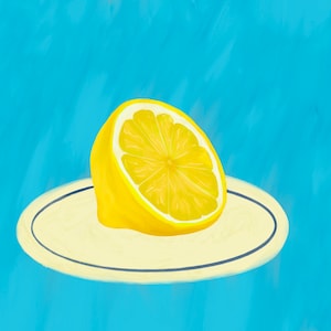 May include: A halved lemon on a white plate with a blue rim, against a light blue background.