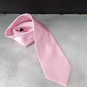 May include: A pink patterned tie with a herringbone design.