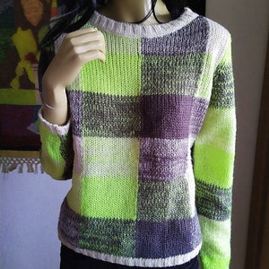 May include: A green, white, and purple plaid sweater with long sleeves.