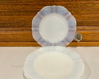 Könnte beinhalten: Drei weiße Dessertteller aus Milchglas mit gewelltem Rand und einem zarten Blumenmuster.