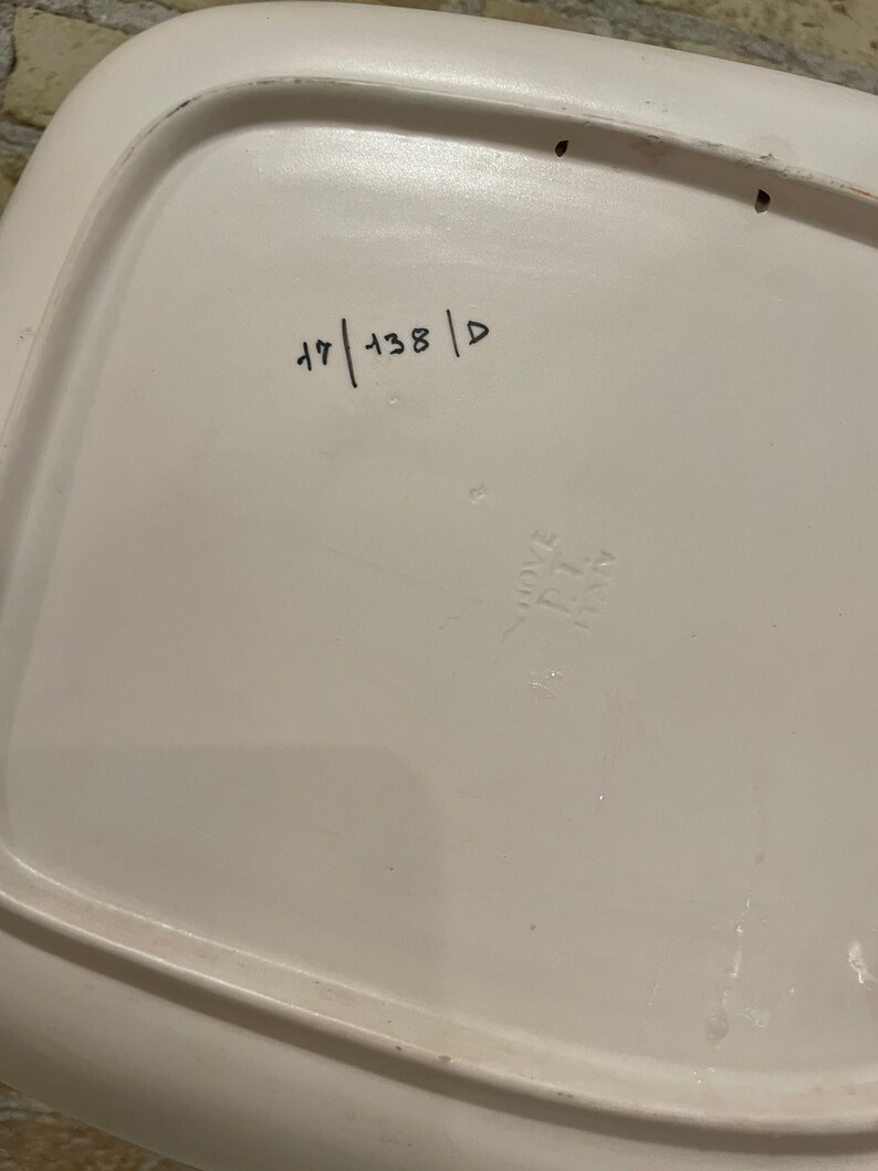 May include: White ceramic plate with a raised rim and a handwritten number "47 | 138 | D" on the bottom.