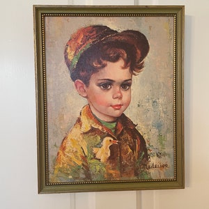 Puede incluir: Una pintura enmarcada de un niño pequeño con ojos grandes que lleva un sombrero y una chaqueta marrones y verdes. Está sosteniendo un pequeño pájaro amarillo en su mano. La pintura está firmada "Medeiros" en la esquina inferior derecha.