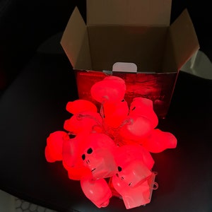 May include: A string of red LED lights shaped like skulls. The lights are in a box with the text "amadecor" on it.